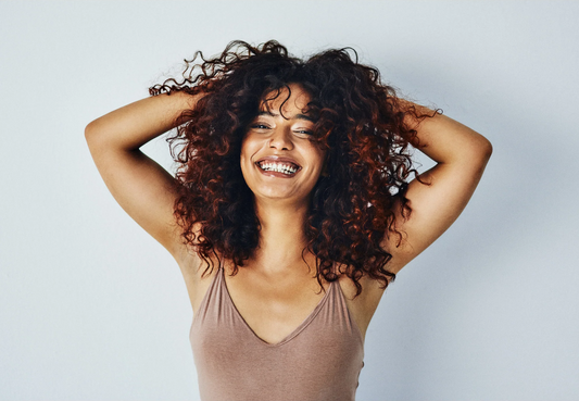 Woman with textured hair illustrating chemical burden in haircare products