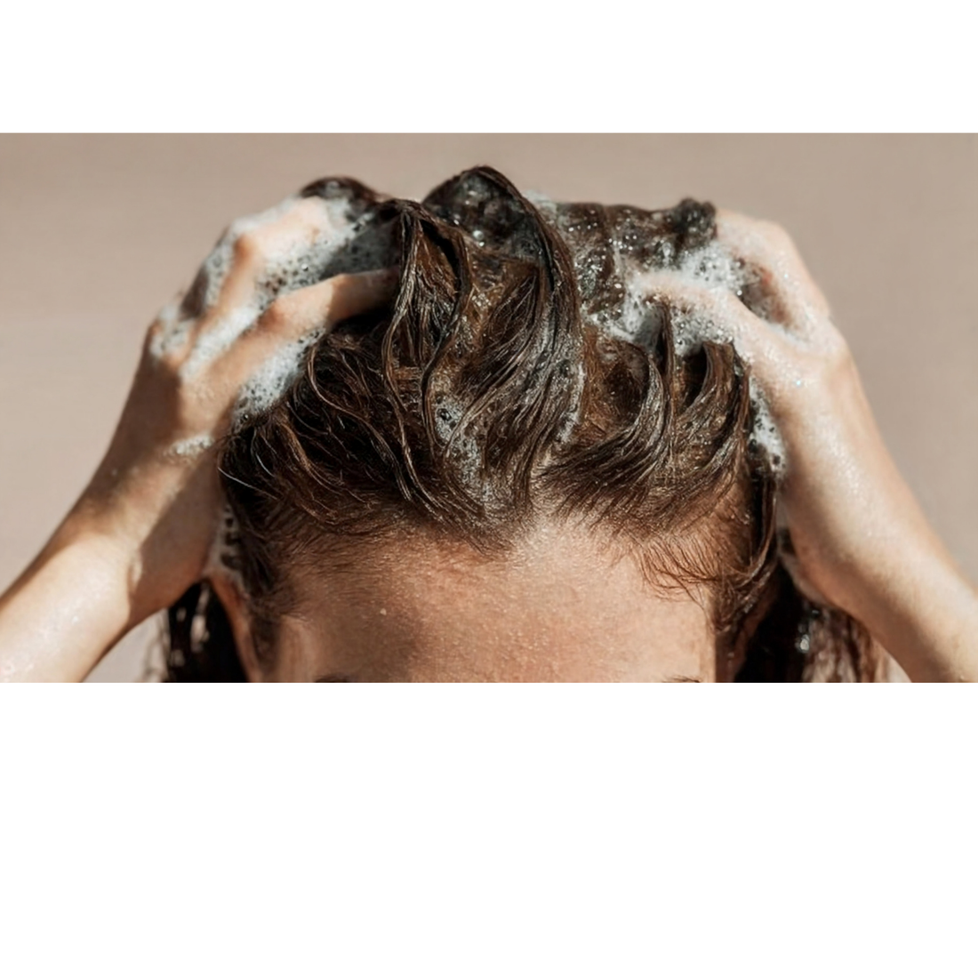 Close-up of hands massaging shampoo into the scalp